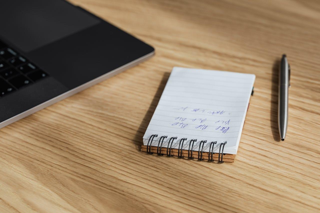 Блокнот для записей и ручка на столе